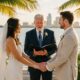 Florida wedding officiant leading a Christian waterfront wedding ceremony as a bride and groom exchange vows beneath palm trees during a sunset celebration.