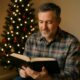 Middle-aged man reading a plain book beside a decorated Christmas tree – What Does a Christmas Chaplain Do