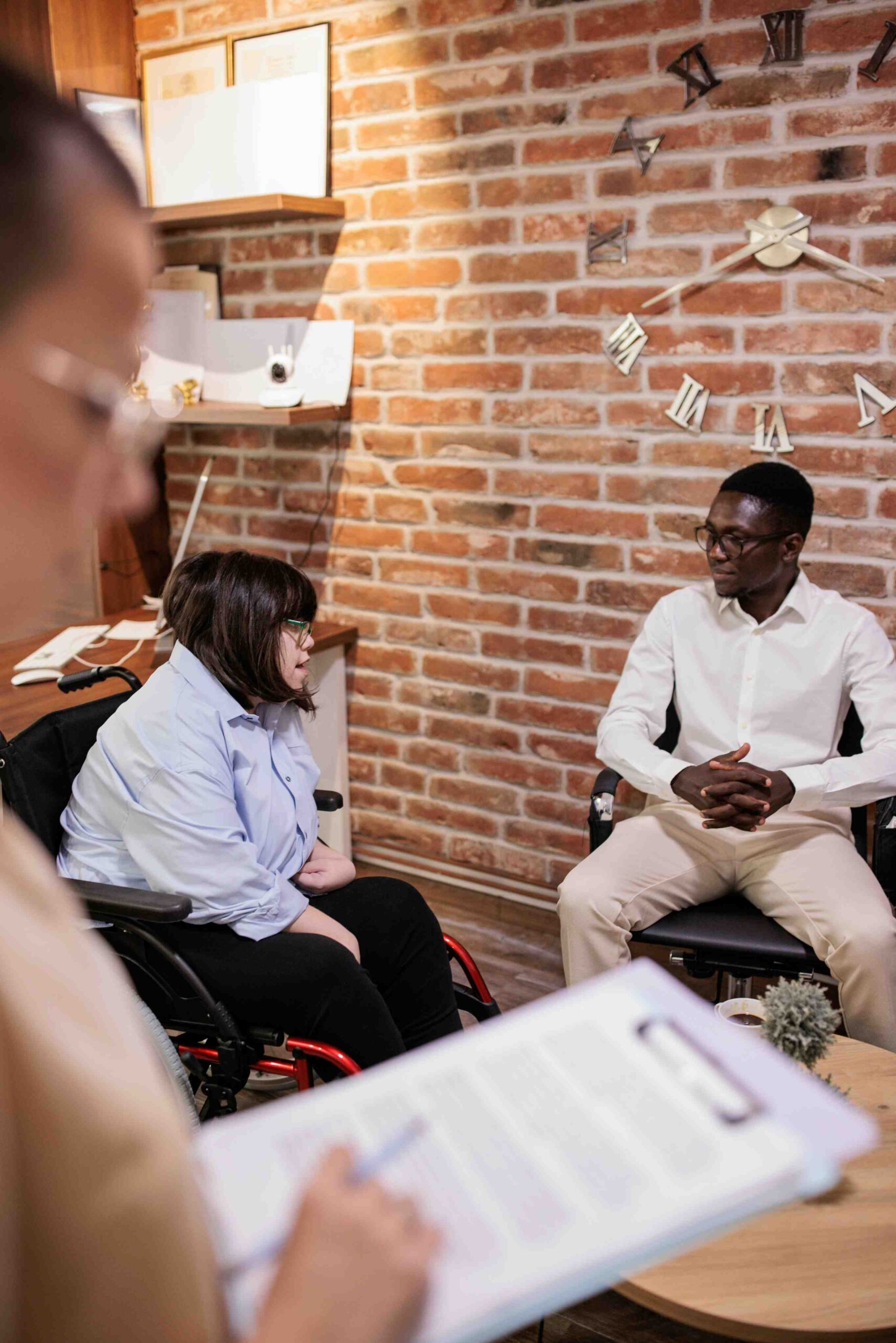 Adults with disabilities participating in a supportive discussion group while receiving compassionate listening and spiritual encouragement in a disability ministry setting.