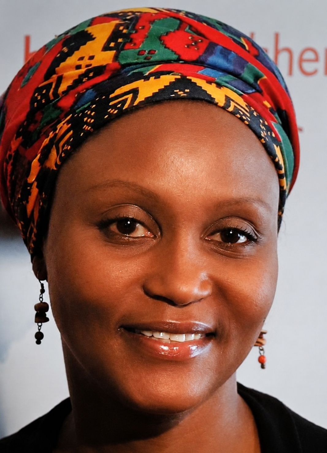 Professional headshot of Anne N., a Christian life coach minister, smiling while wearing a colorful patterned headscarf and earrings.