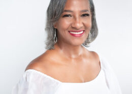 Professional headshot of Christian life coach minister Cynthia smiling in a white blouse against a light background.