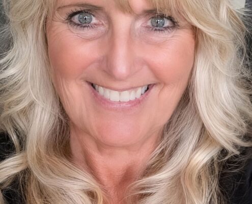 Portrait of Christian life coach minister Jaymie smiling in a professional headshot with blonde hair and a welcoming expression.
