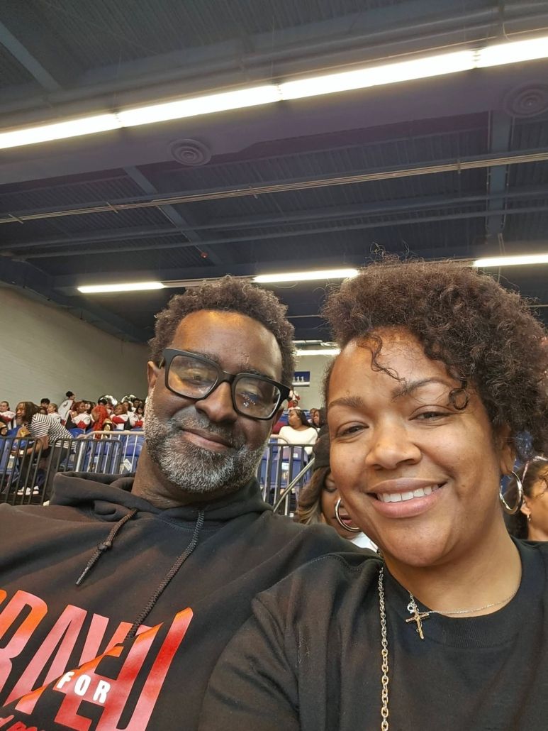 Monique and her husband smile together at a community event, reflecting Christian leadership, joyful fellowship, and a Christ-centered marriage.